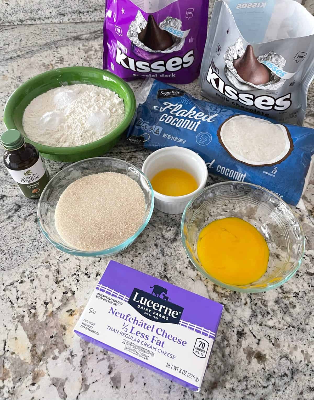 Ingredients including Hershey's kisses, flaked coconut, flour, Truvia, egg yolk, orange juice, cream cheese and almond extract.