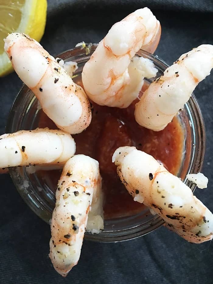6 Shrimp Cocktail Dipped in Cocktail Sauce.
