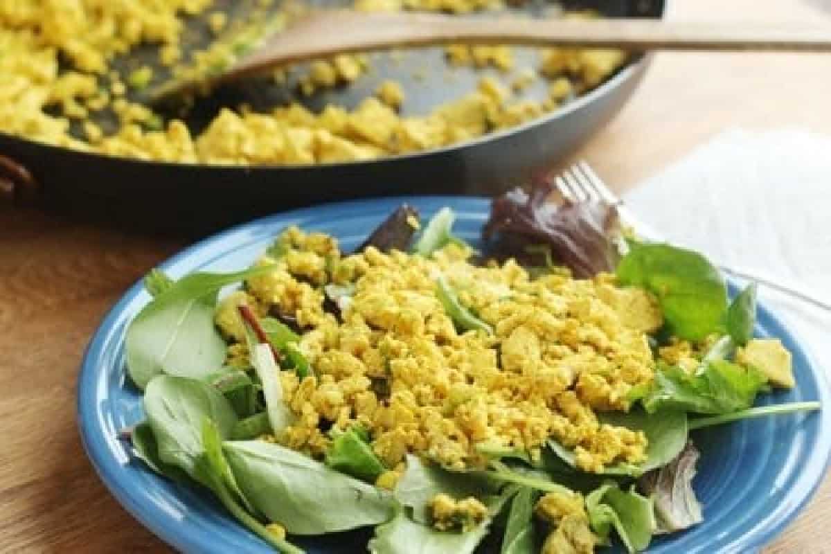 Tofu Scramble on Bed of Spinach with Skillet in Background
