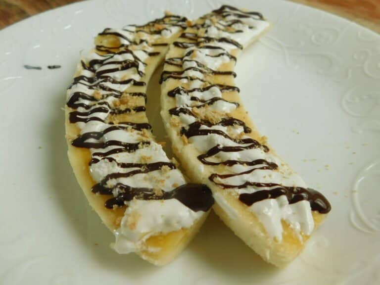 Horizontally sliced banana drizzled with chocolate and marshmallow syrup.