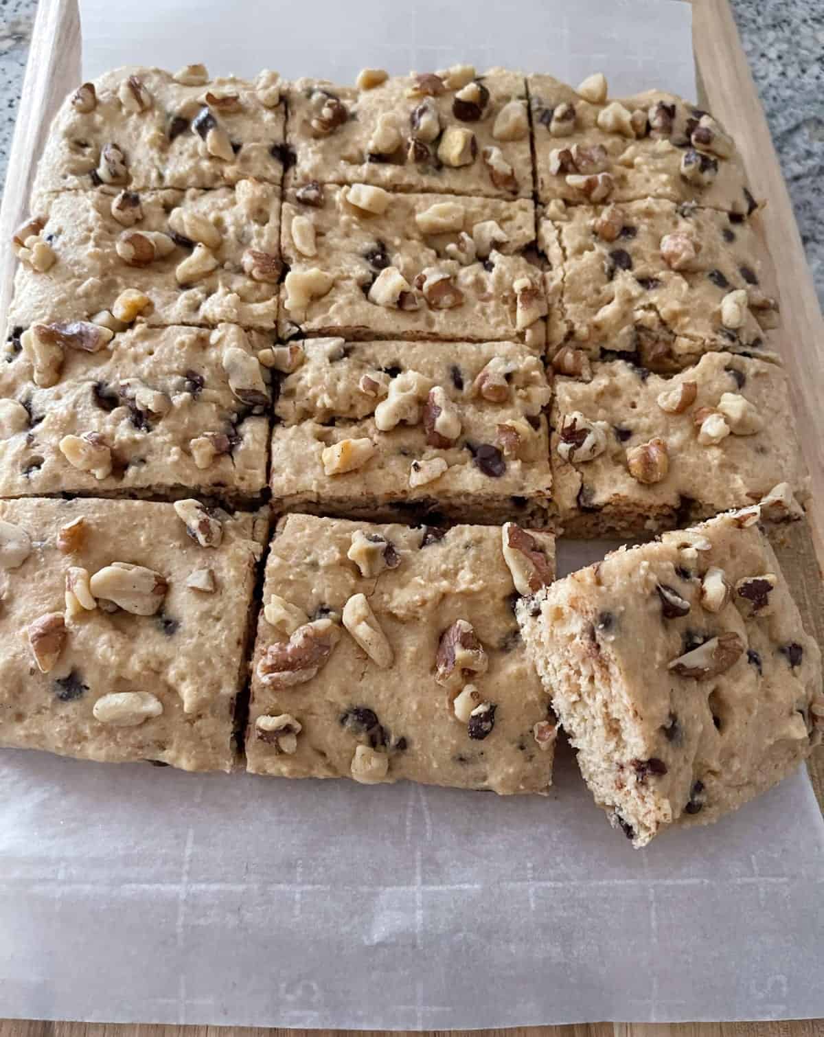 12 pieces of Chocolate Chip Kodiak Quick Cake on parchment on cutting board.