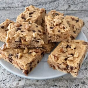 white plate with squares of chocolate chip quick cake artfully stacked on a gray granite counter