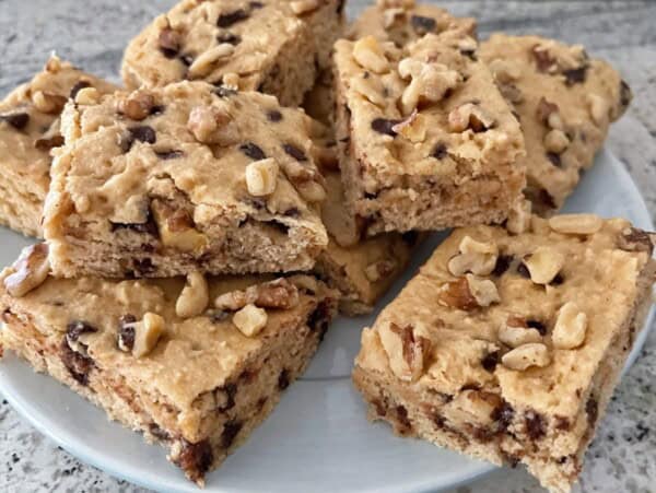 white plate with squares of chocolate chip quick cake artfully stacked on a gray granite counter