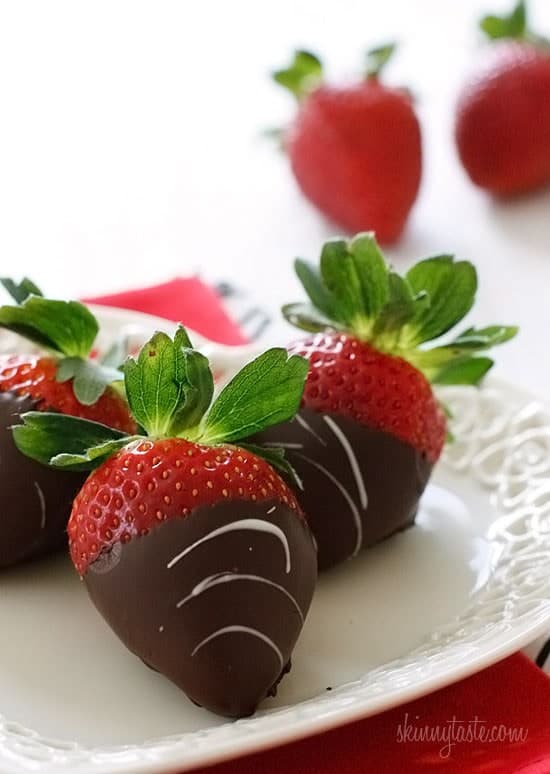 Chocolate dipped strawberries on white plate.