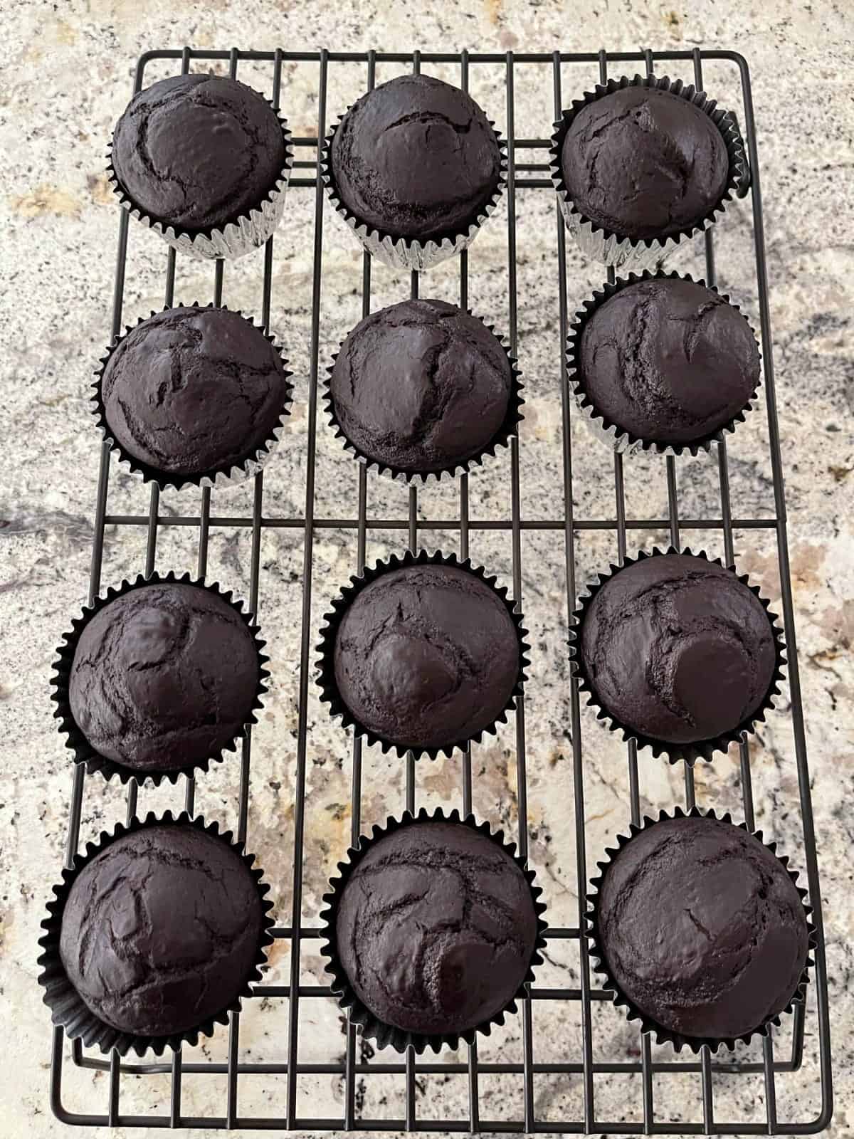 Chocolate cupcakes on wire cooling rack.