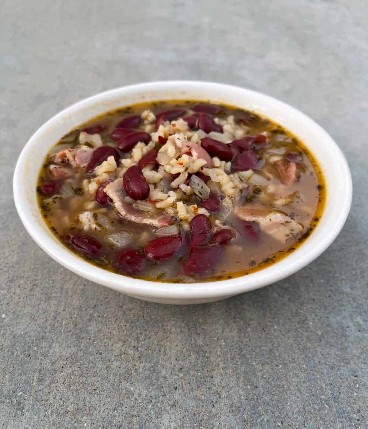 Jamaican red beans and rice soup in white bowl.