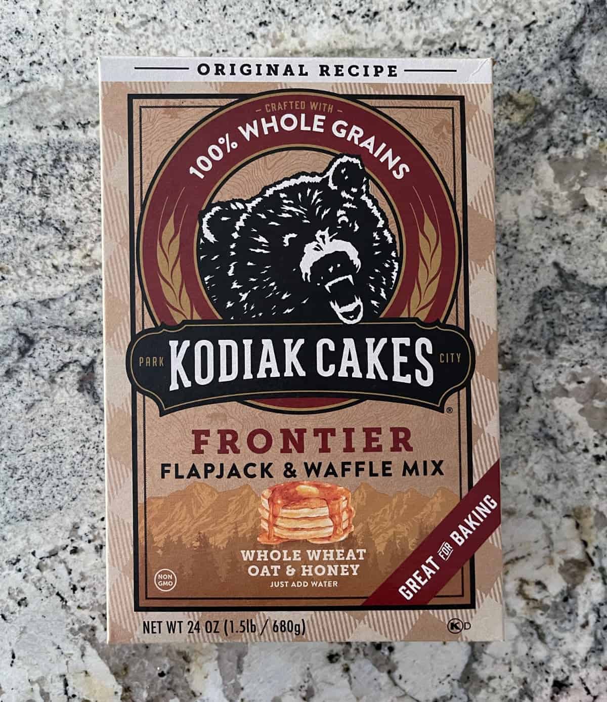 Box of Kodiak Cakes Frontier Flapjack and Waffle Mix with whole wheat, oat and honey on granite.