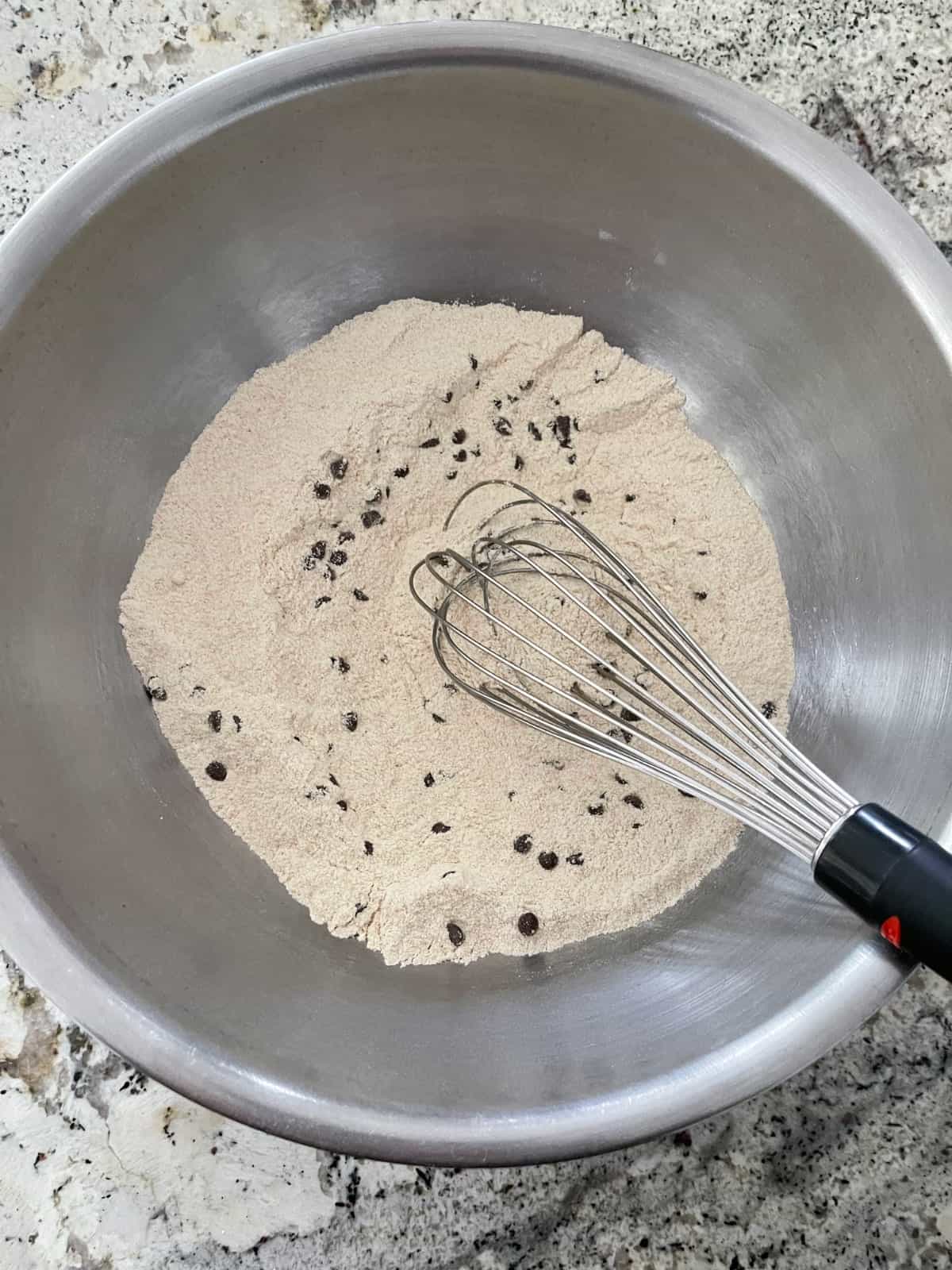 Whisking Kodiak Cakes Frontier Flapjack and Waffle Mix with Truvia no-calorie sweetener and mini chocolate chips in mixing bowl.