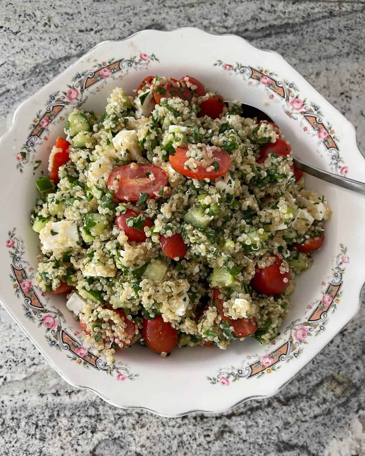 Quinoa tabbouleh salad with feta in white bowl.