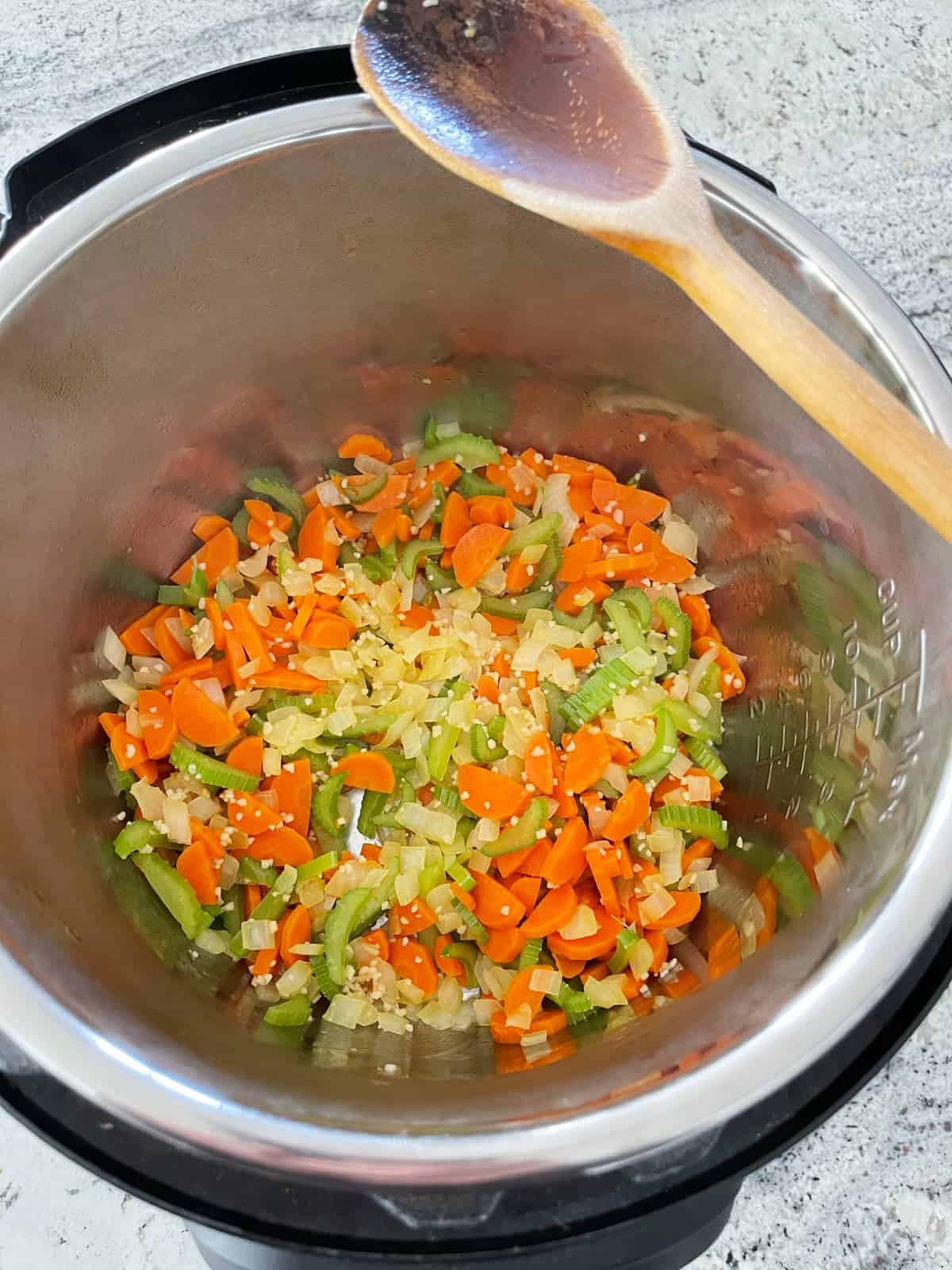 Sautéing onions, carrots and celery with minced garlic in Instant Pot.