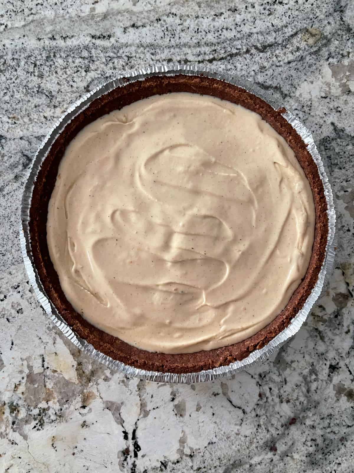 Chocolate pie crust filled with peanut butter ice cream on granite.