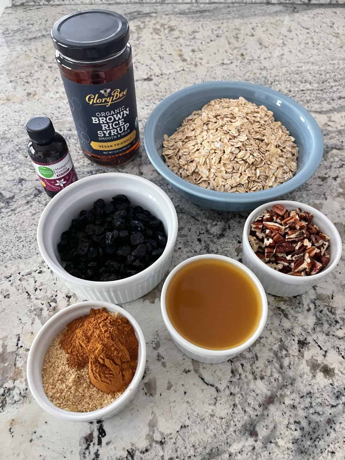 Ingredients including brown rice syrup, vanilla, rolled oats, dried blueberries, chopped pecans, unsweetened apple juice, flax meal and ground cinnamon.