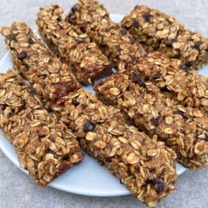 Round white plate of oatmeal spice bars decoratively arranged sitting on granite countertop
