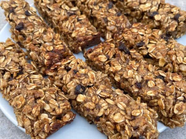 Round white plate of oatmeal spice bars decoratively arranged sitting on granite countertop