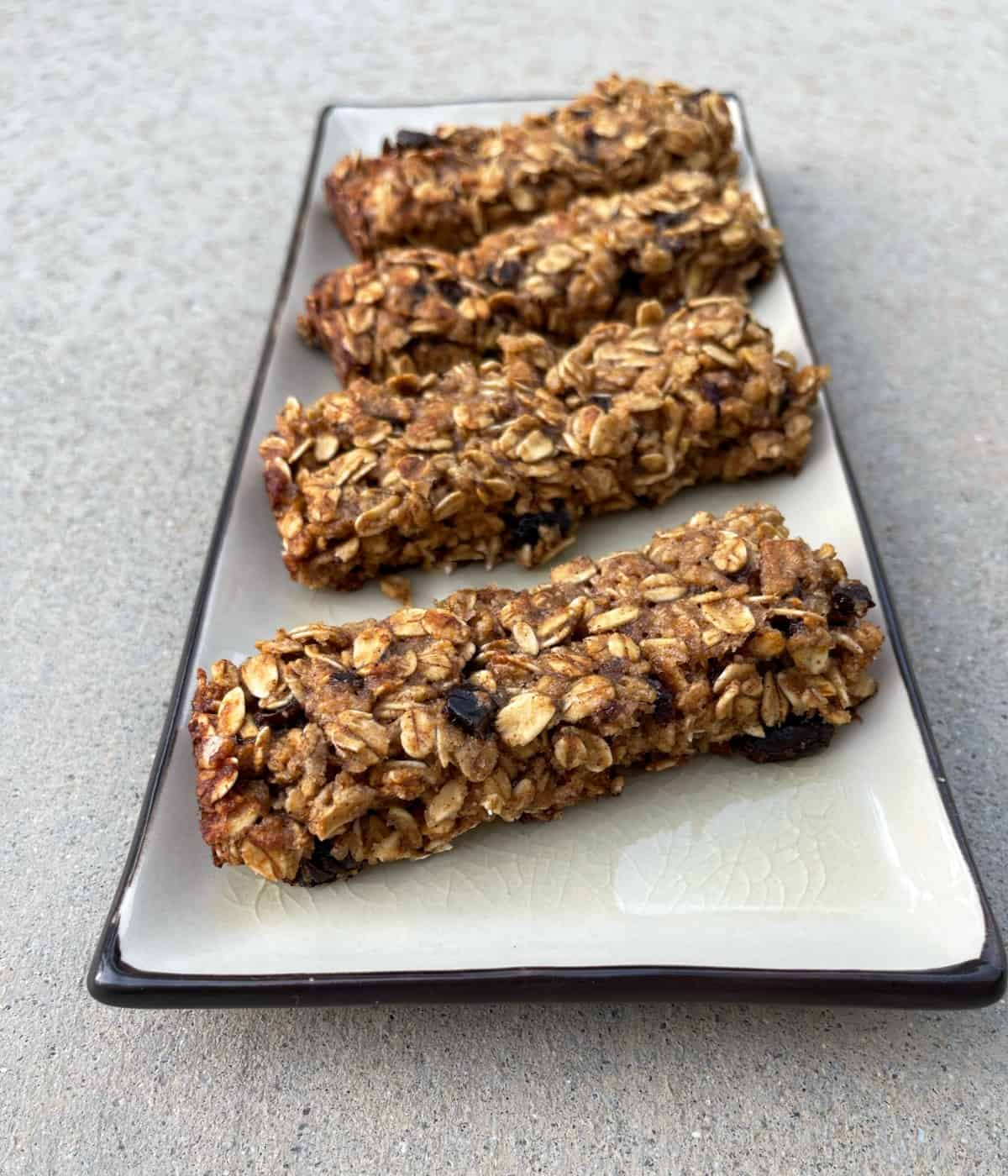 Four gluten-free oatmeal spice bars on small serving plate.