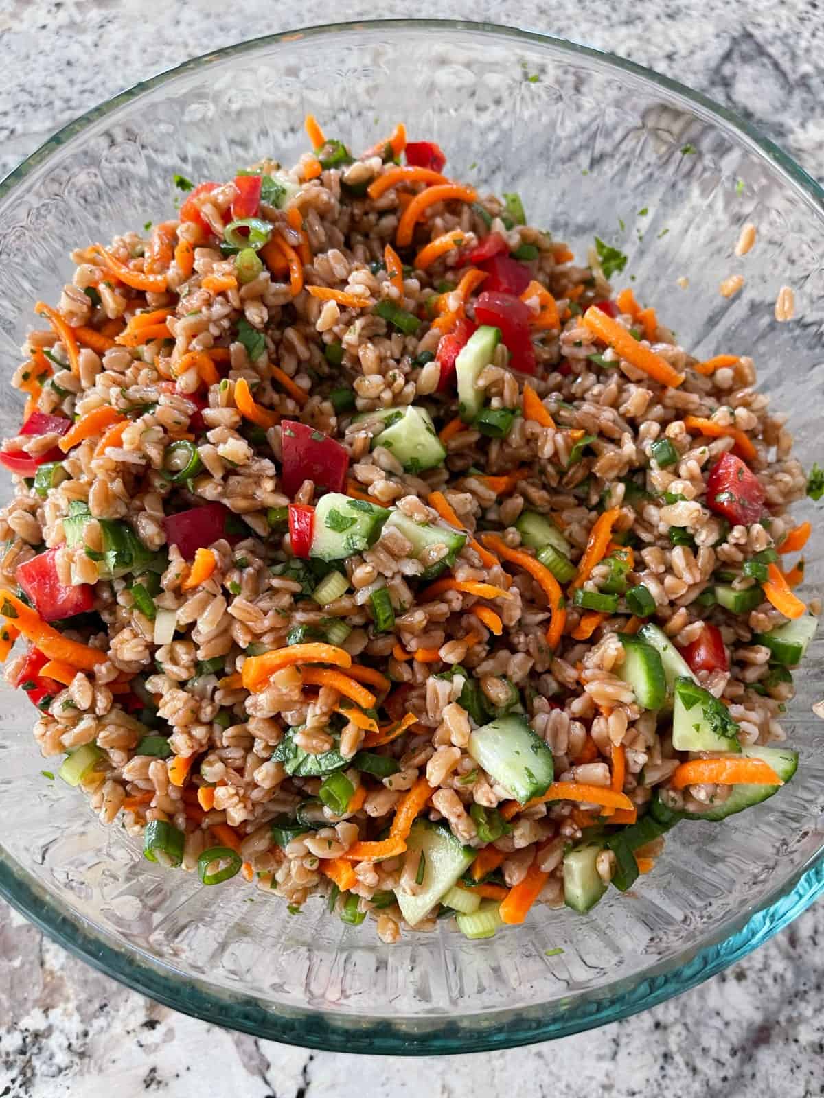 Mixing Thai-style farro salad in large glass bowl.
