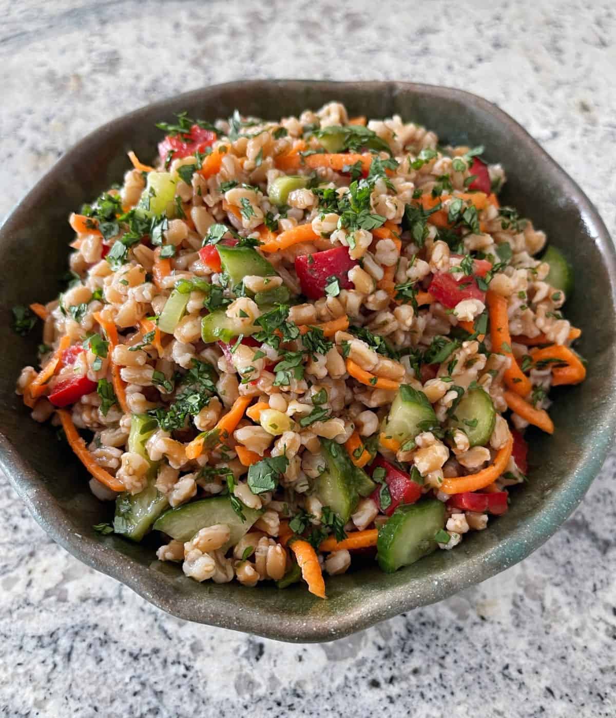 Thai-style farro salad in green pottery serving bowl.