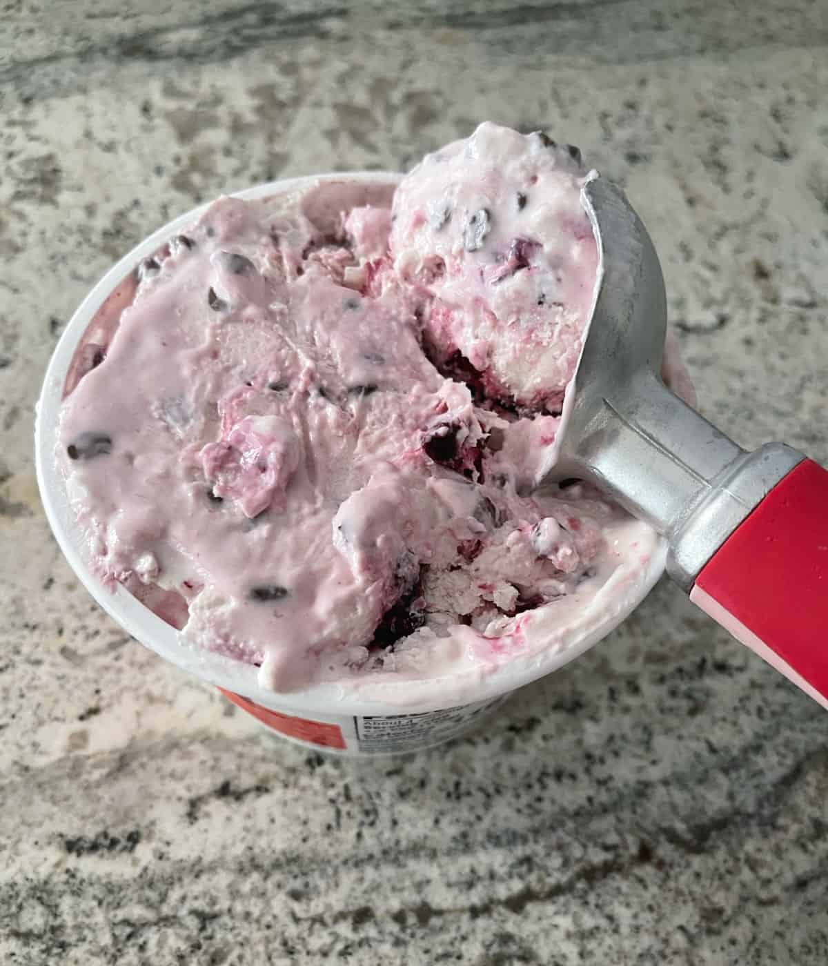 Picking cottage cheese ice cream with chocolate chips and cherries.