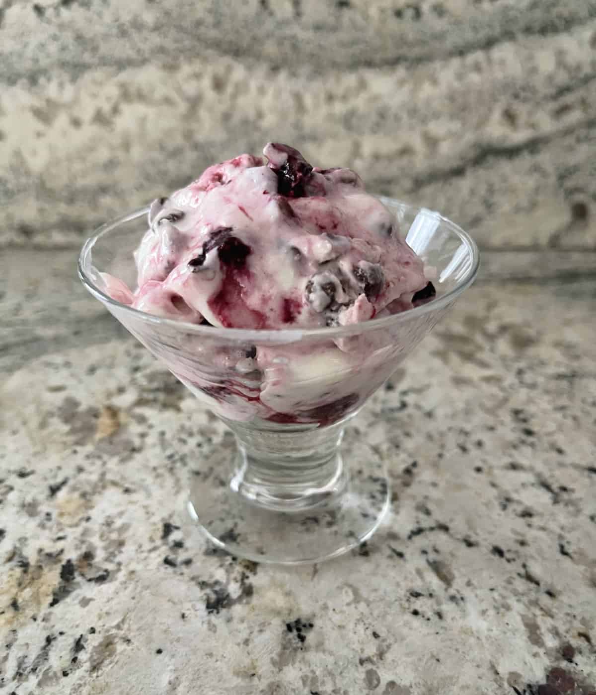 Cherry Chocolate Chip Cottage Cheese Ice Cream in small dessert glass on granite counter.