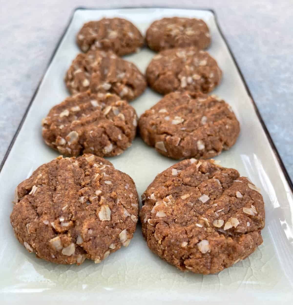Freshly baked coconut almond butter cookies on a rectangular serving tray.