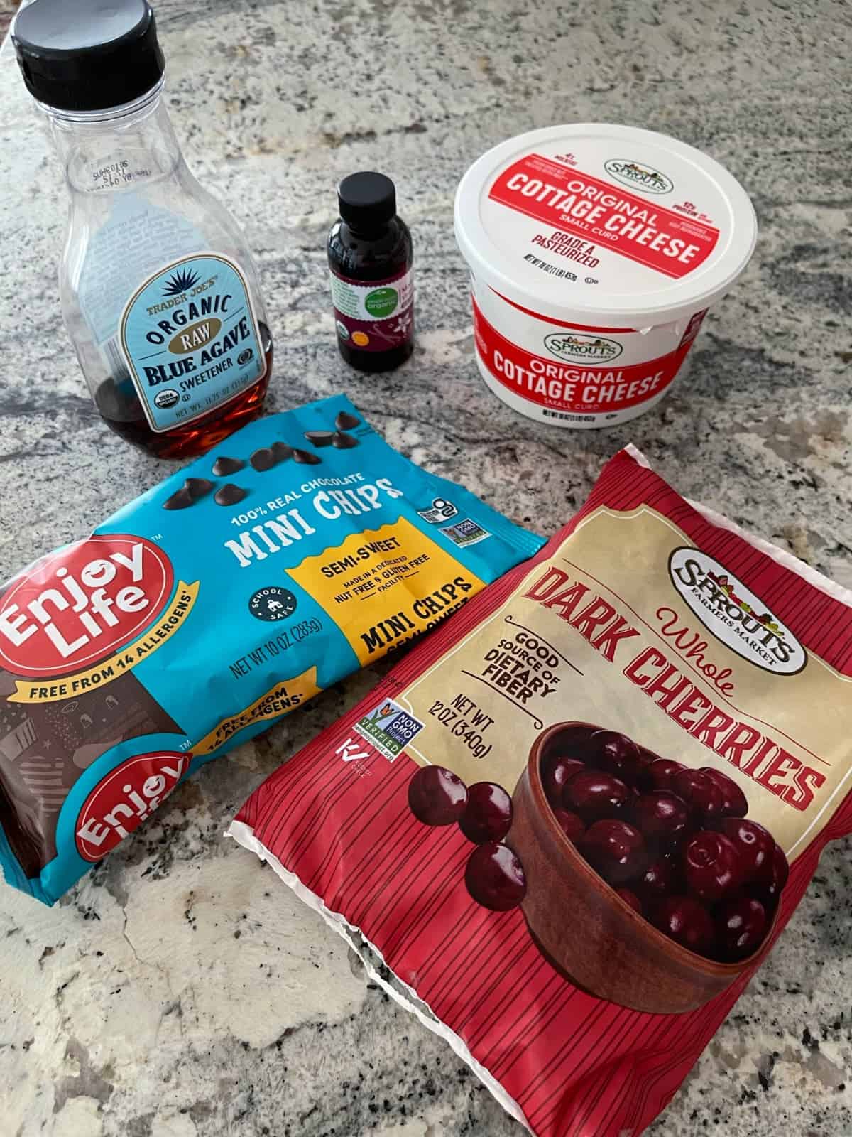 Ingredients including cottage cheese, mini chocolate chips, frozen dark cherries, agave nectar and vanilla extract.