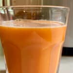 Glass of Carrot Golden Beet Pineapple Juice in front of Juicer