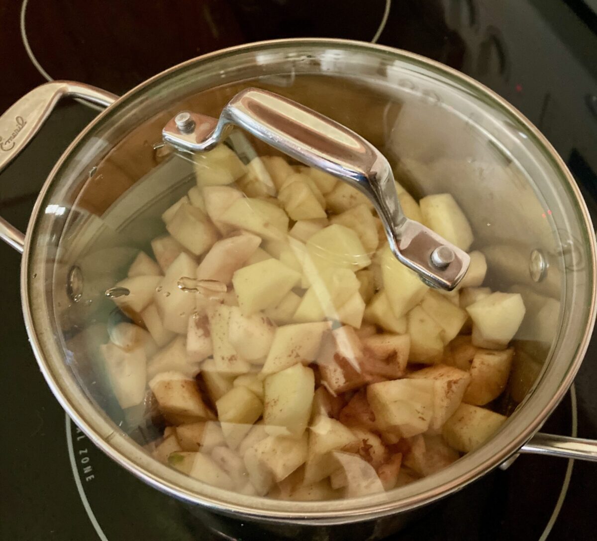 Covered pot filled with chopped apples, pears, cinnamon, water and lemon juice.