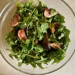 Fig Arugula Salad in large clear glass bowl shot from above