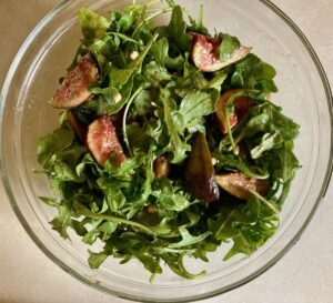 Fig Arugula Salad in large clear glass bowl shot from above