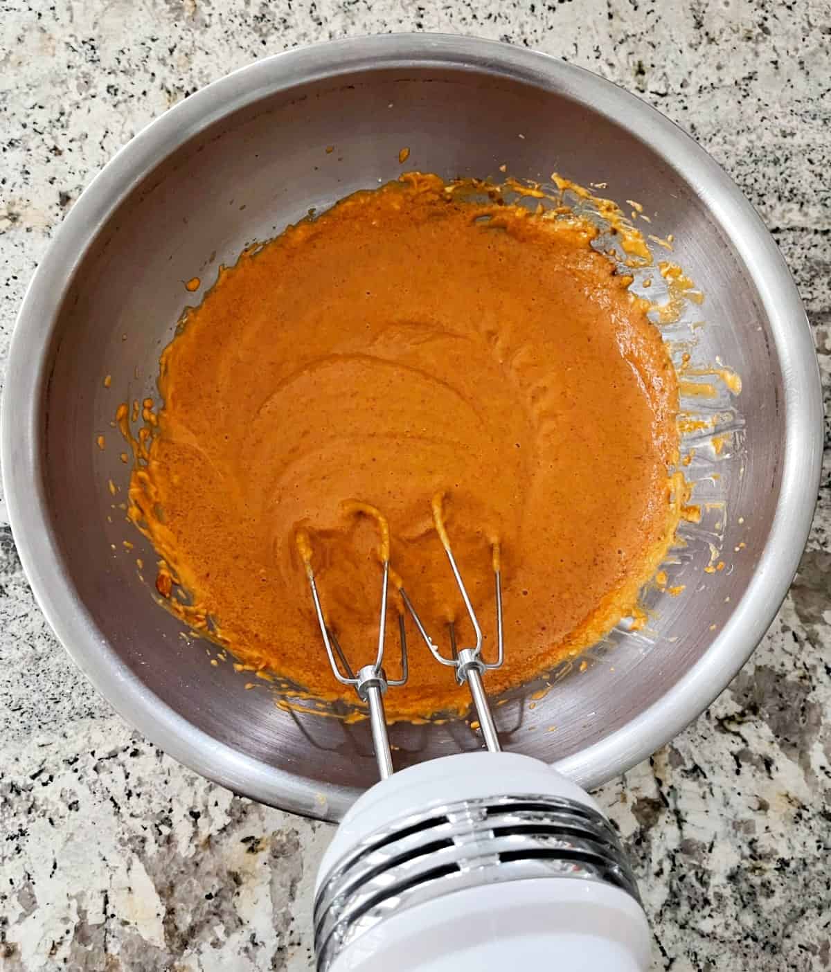 Beating light cream cheese, pure pumpkin, cornstarch, eggs, Truvia, brown sugar, cinnamon, ginger, nutmeg and vanilla with electric hand mixer in stainless bowl.