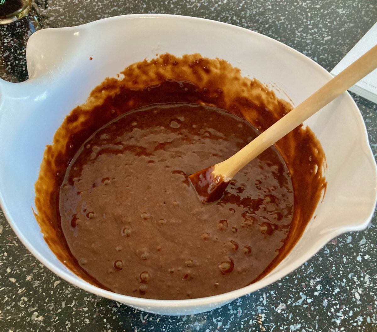 Mixing double ginger chocolate gingerbread batter in mixing bowl with a wooden spoon.