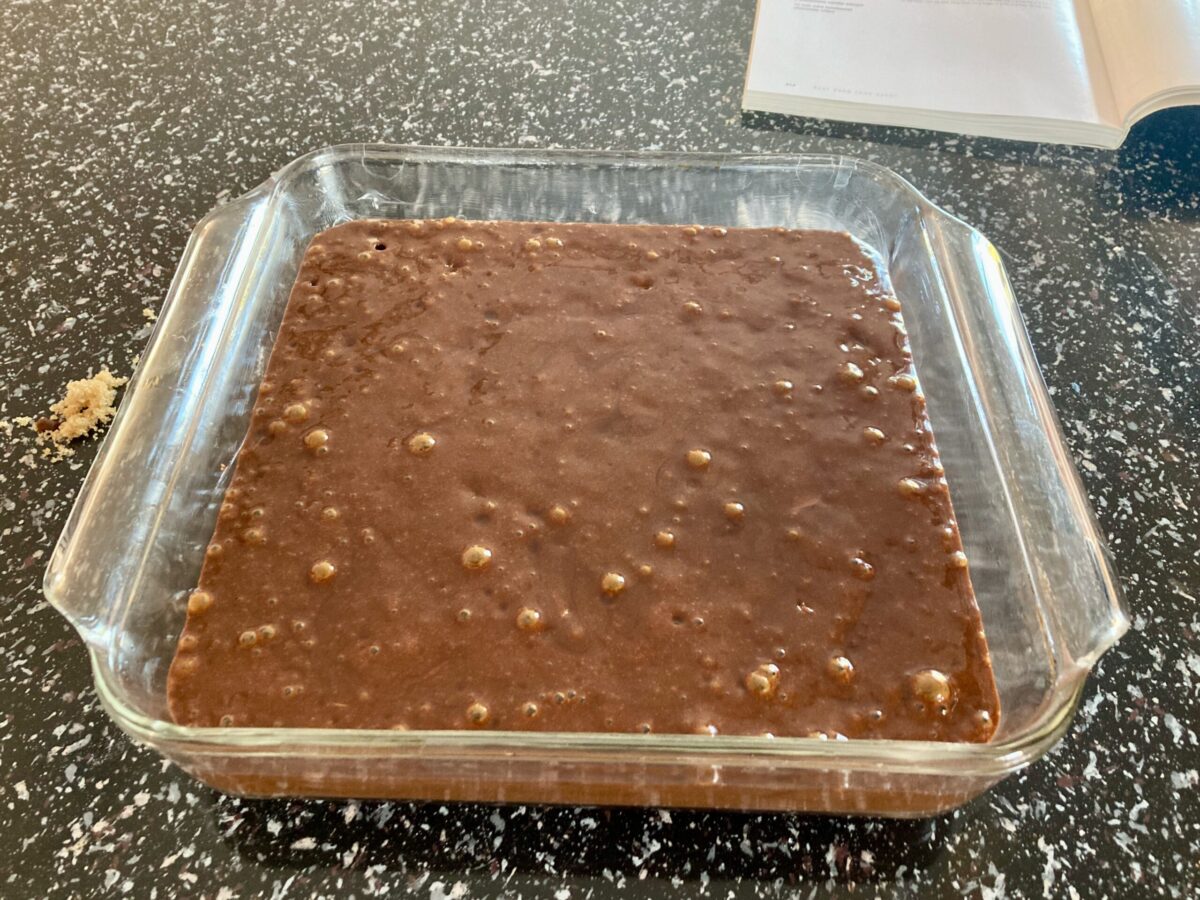Unbaked double ginger chocolate gingerbread in glass baking dish.