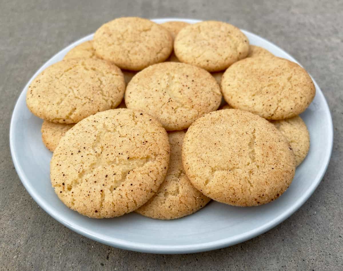 Fresh baked eggnog snickerdoodle cookies on round blue plate.