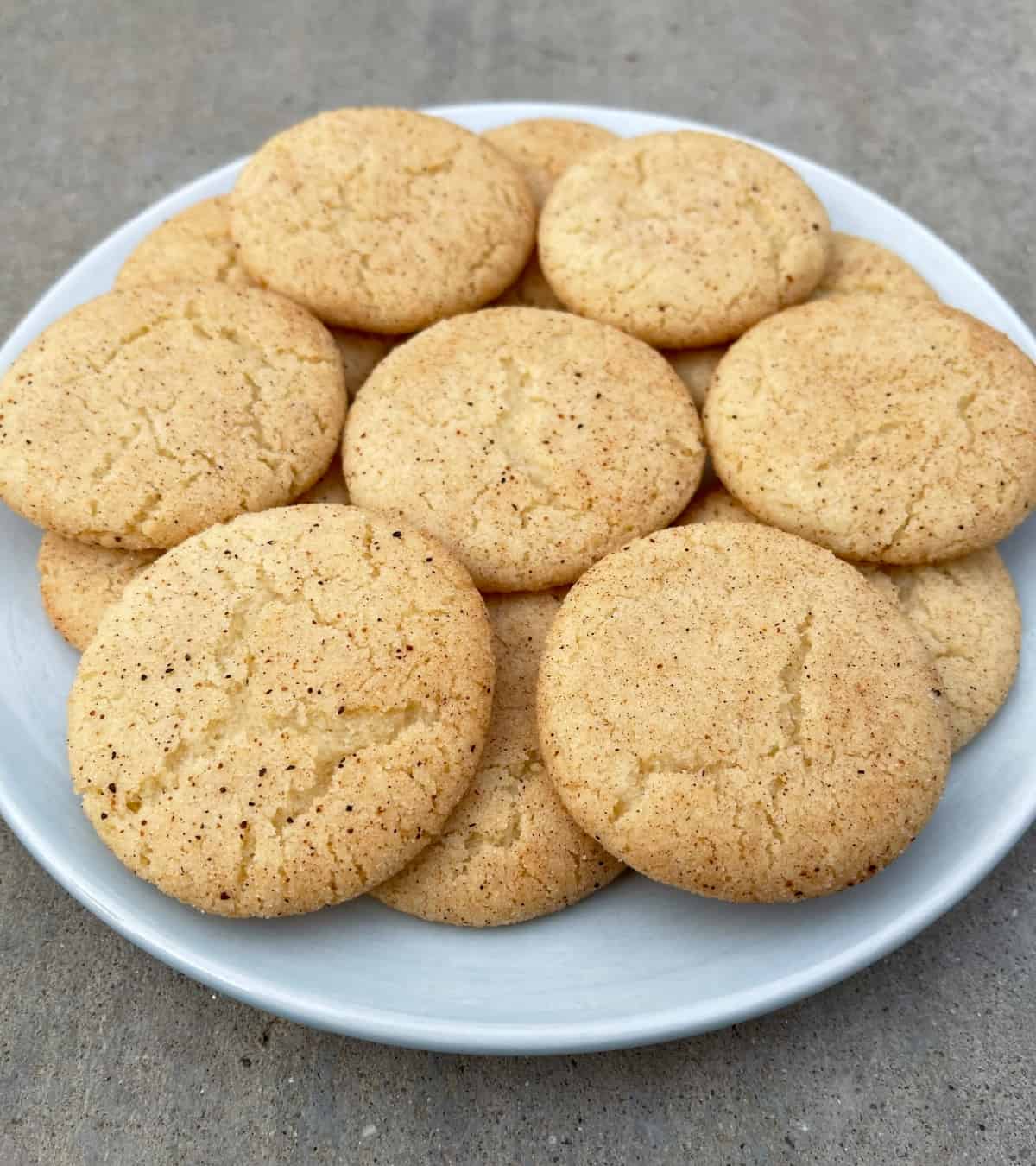Fresh baked eggnog snickerdoodles on round blue plate.