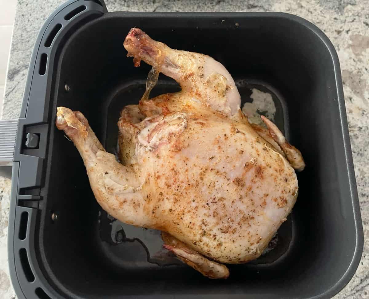 Cooking whole chicken in air fryer with breast side up.