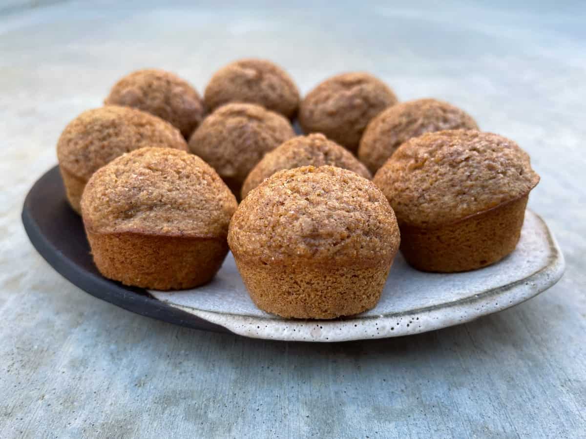 Mini cinnamon apple muffins on ceramic serving plate.
