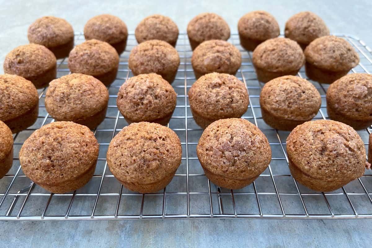 Cinnamon applesauce mini muffins cooling on wire rack.