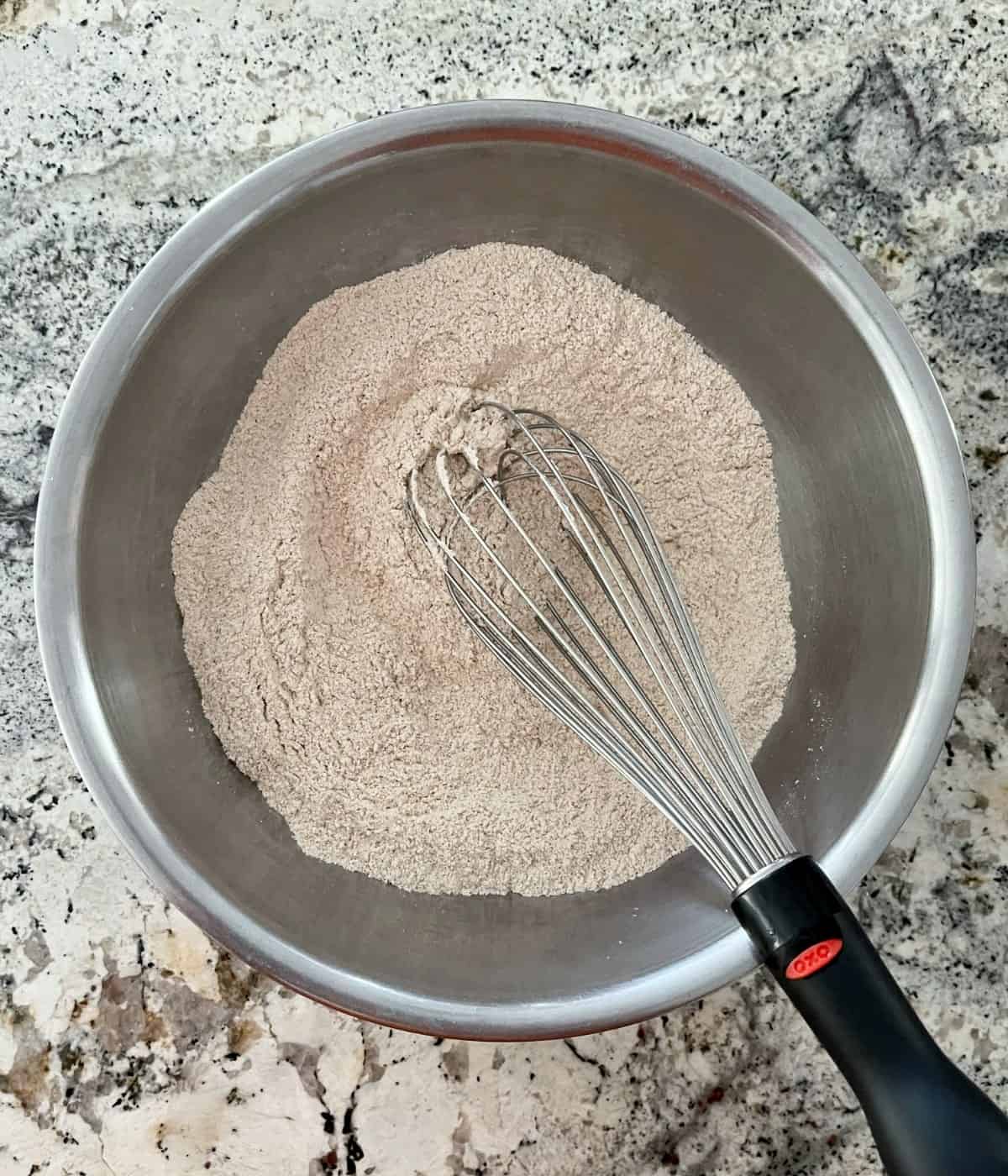 Whisking all-purpose flour, white whole wheat flour, Truvia, baking soda, baking powder and cinnamon in mixing bowl.