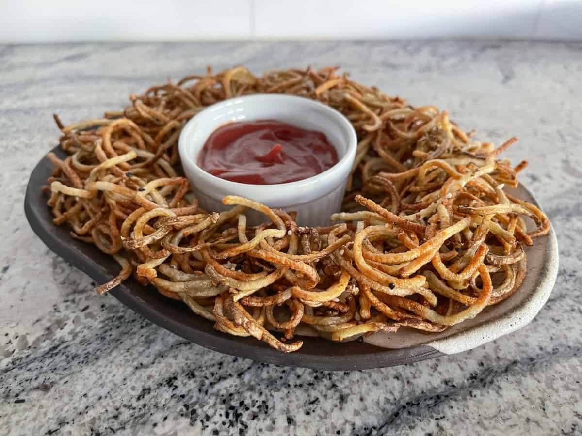 Air fryer everything bagel shoestring fries on serving platter with no sugar added ketchup.