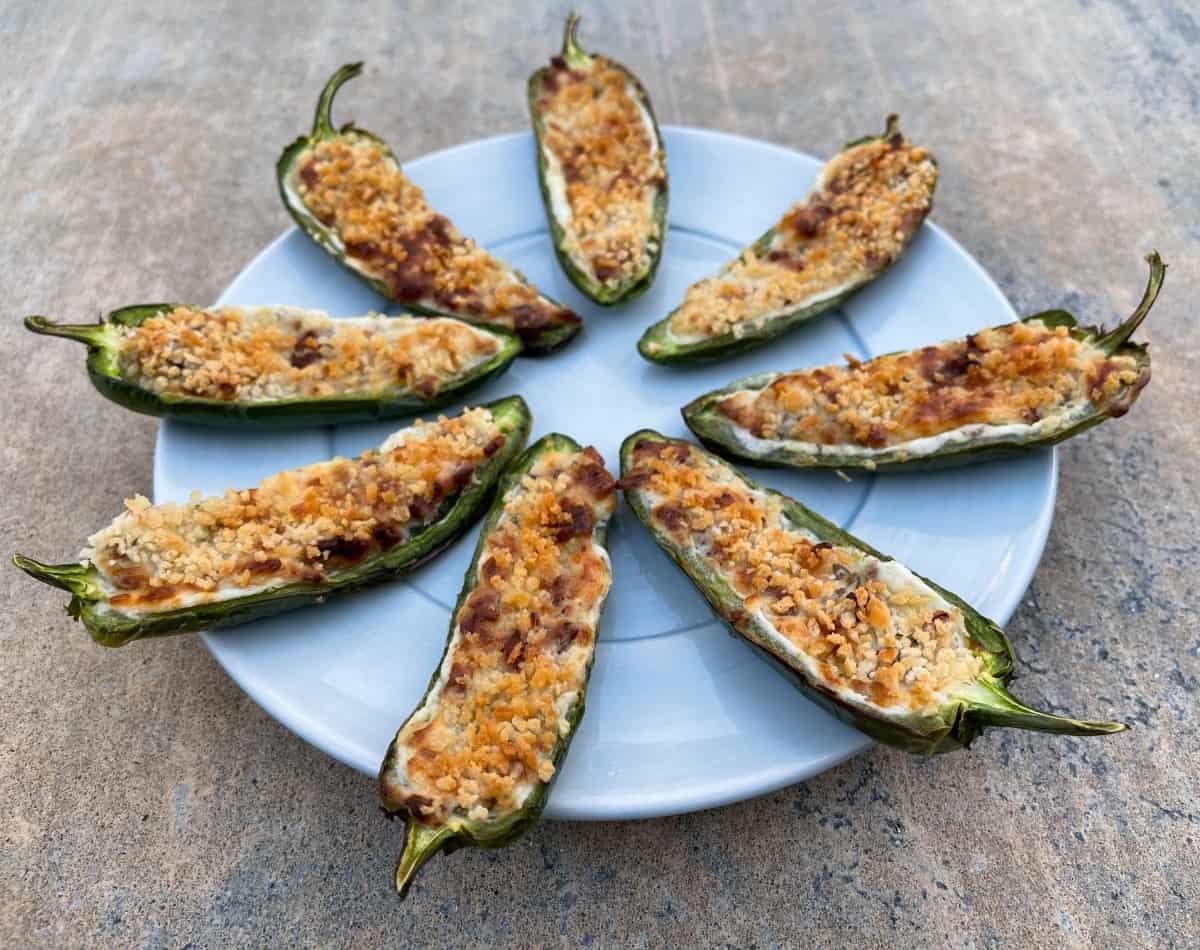 Air fryer jalapeno poppers on round blue plate.
