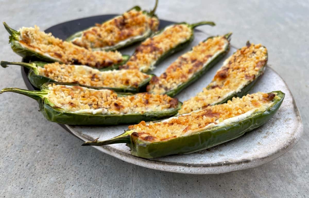 Cheesy air fryer jalapeno poppers on small serving plate.