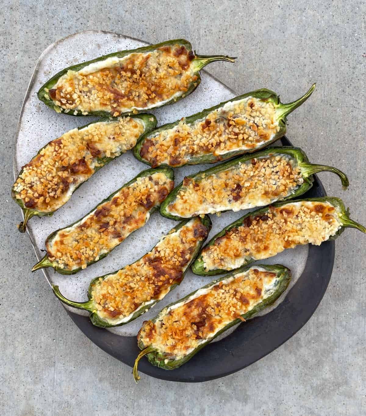 Open-face air fried jalapeno poppers on ceramic serving plate.