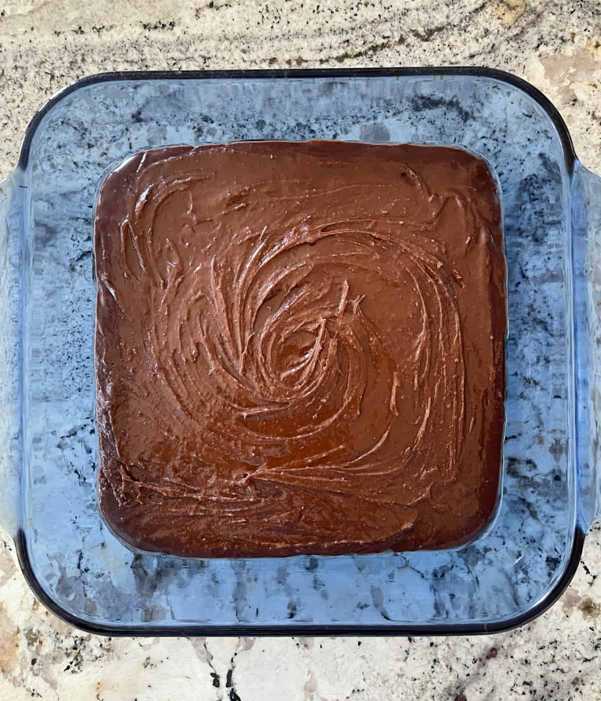 Unbaked Halo Top fudge brownies in blue glass baking dish on granite.