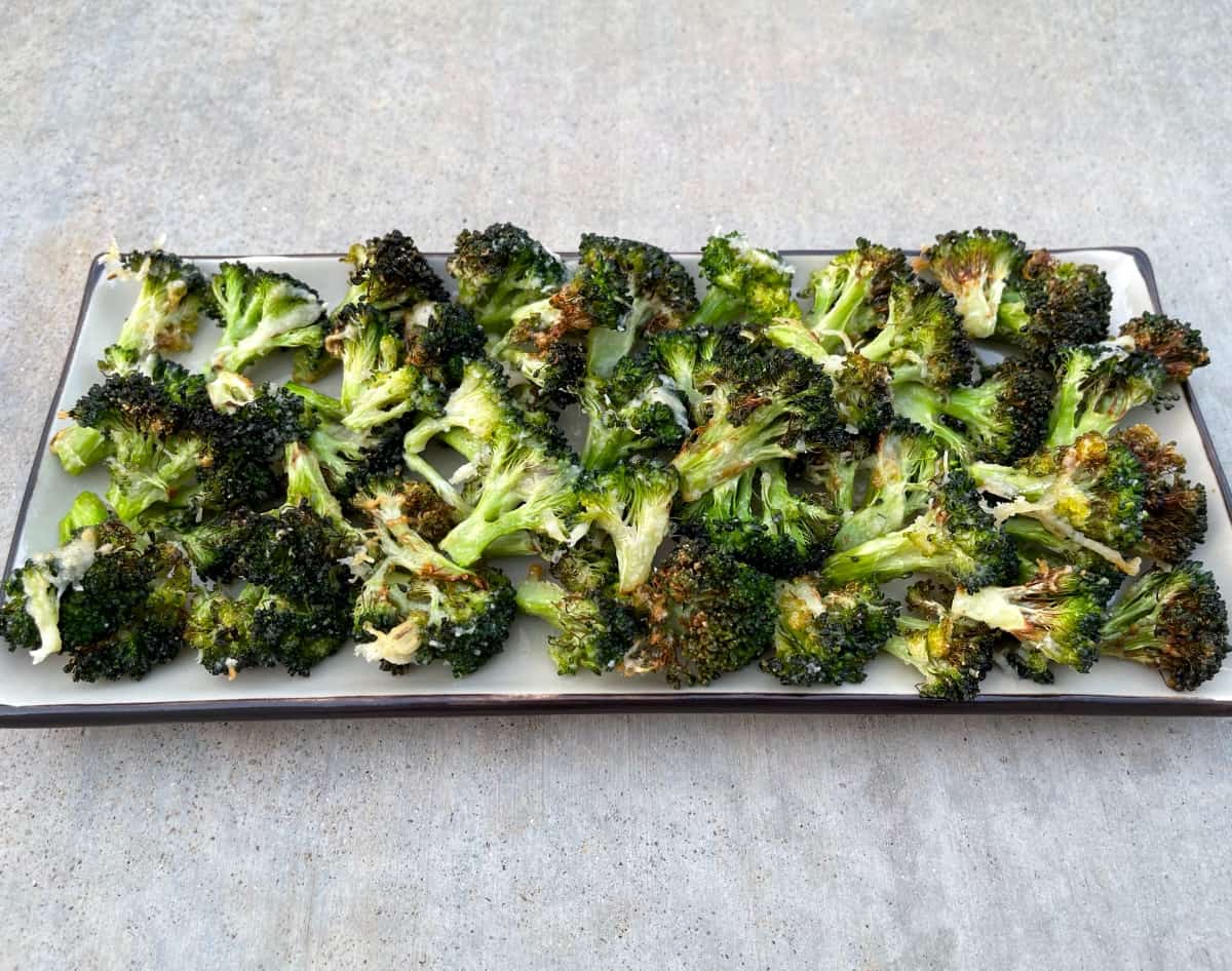 Air fryer roasted garlic parmesan broccoli florets in serving platter.