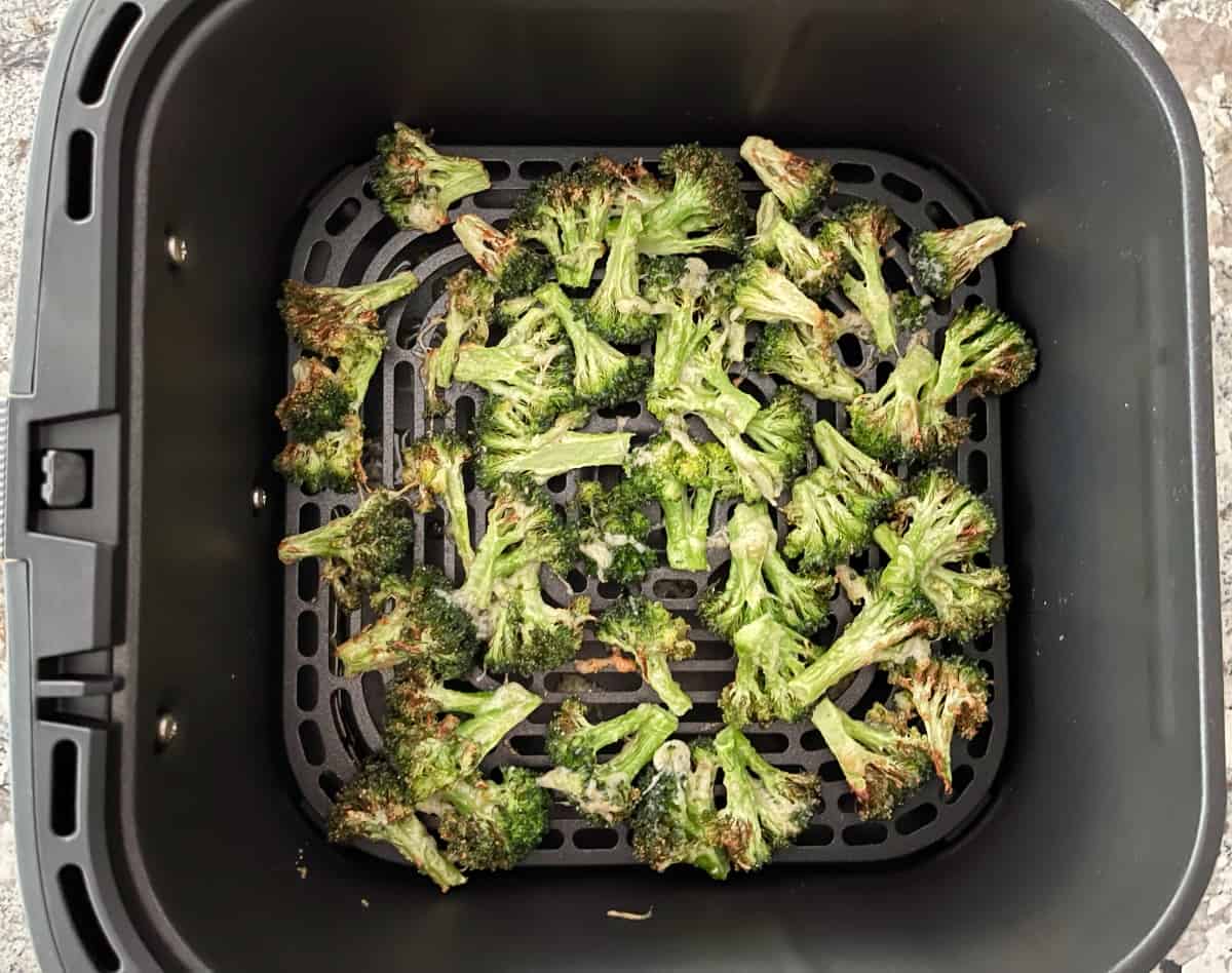 Roasted garlic parmesan broccoli in air fryer basket.