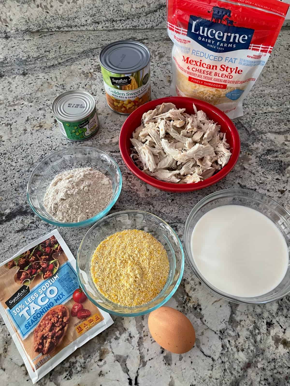 Ingredients including shredded cheese, chicken, canned corn, chopped green chiles, Bisquick, cornmeal, milk, egg and reduced sodium taco seasoning mix.