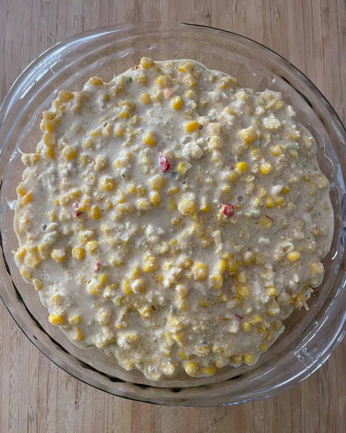 Unbaked chicken tamale pie in glass pie dish.