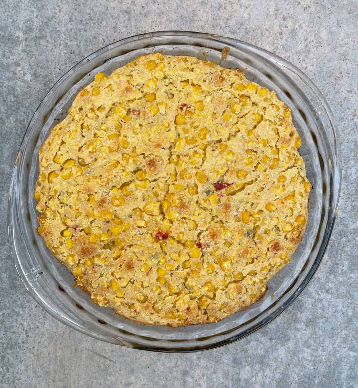 Fresh baked chicken tamale pie in glass pie dish.