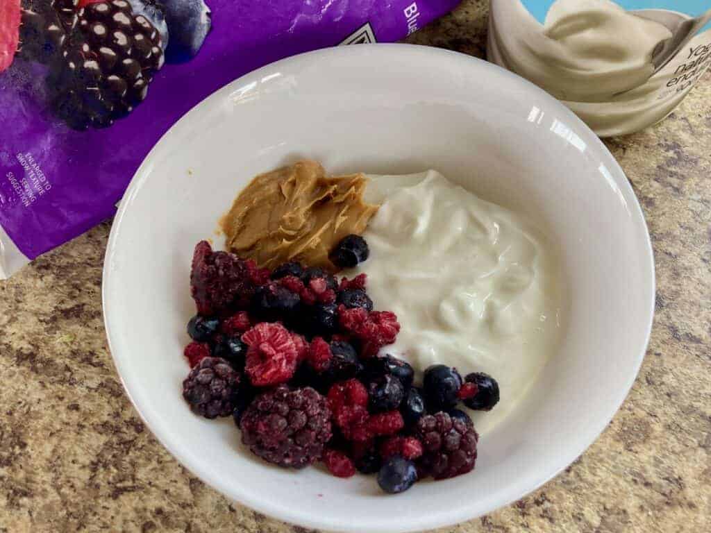 White Bowl with Yogurt, Peanut Butter and frozen Mixed Berries