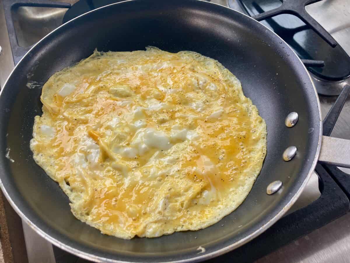 Omelette cooking in nonstick skillet.